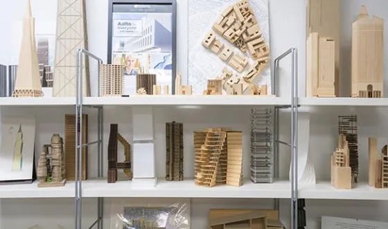A variety of architectural models and scale building designs sit on open shelves.