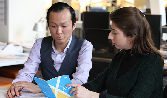 Two architects reviewing an AXP program brochure.