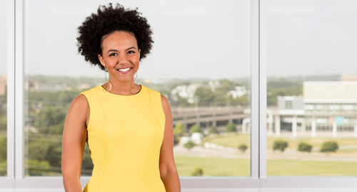An architect poses in front of a window for NCARB's Architect Spotlight series.