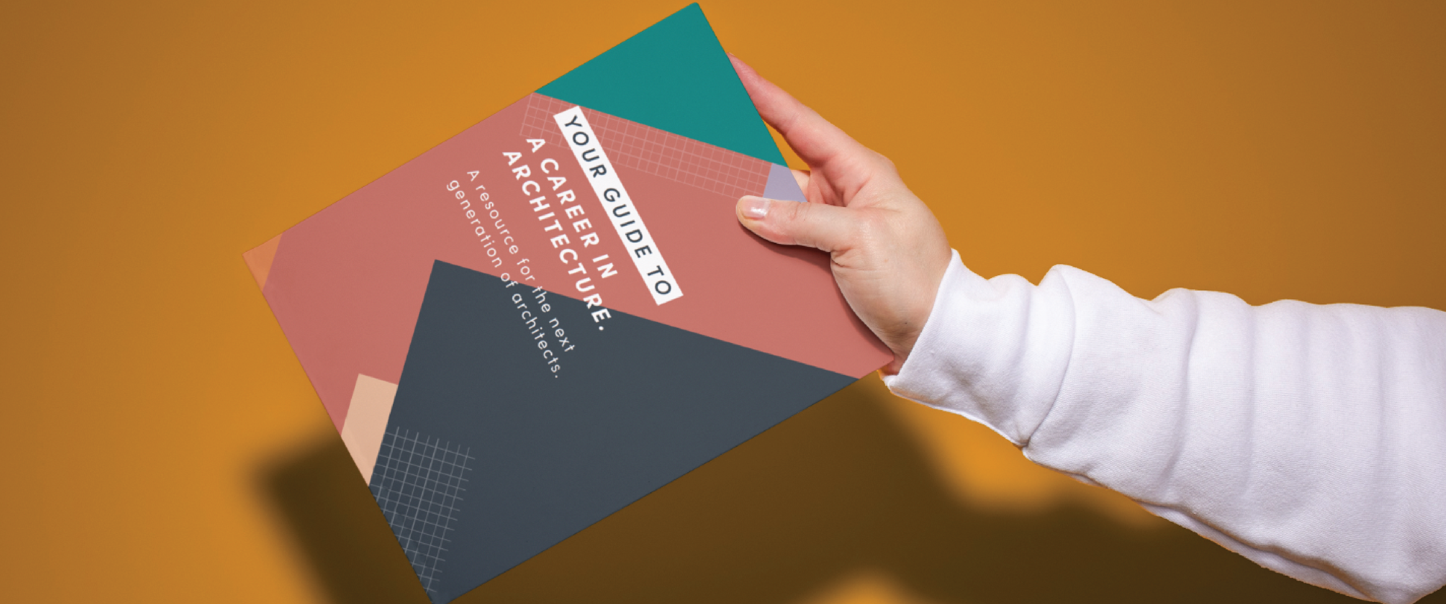 A hand holds out one of NCARB's k-12 booklets. 