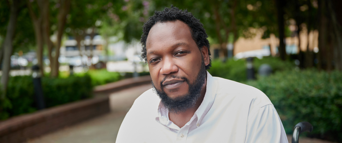 Headshot of Charles Jordan sitting in a park with trees in background