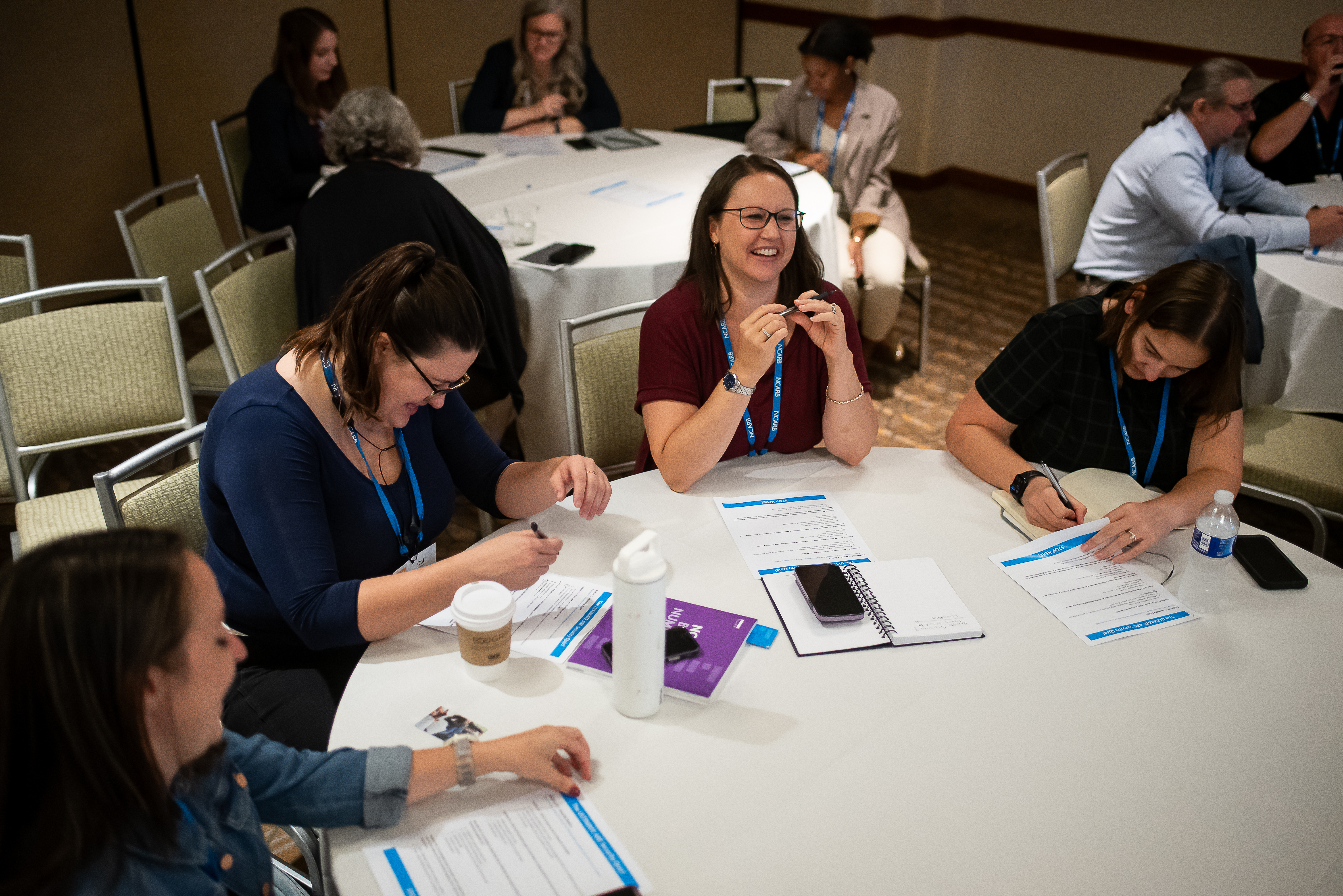 Conference attendees conversing at a table.