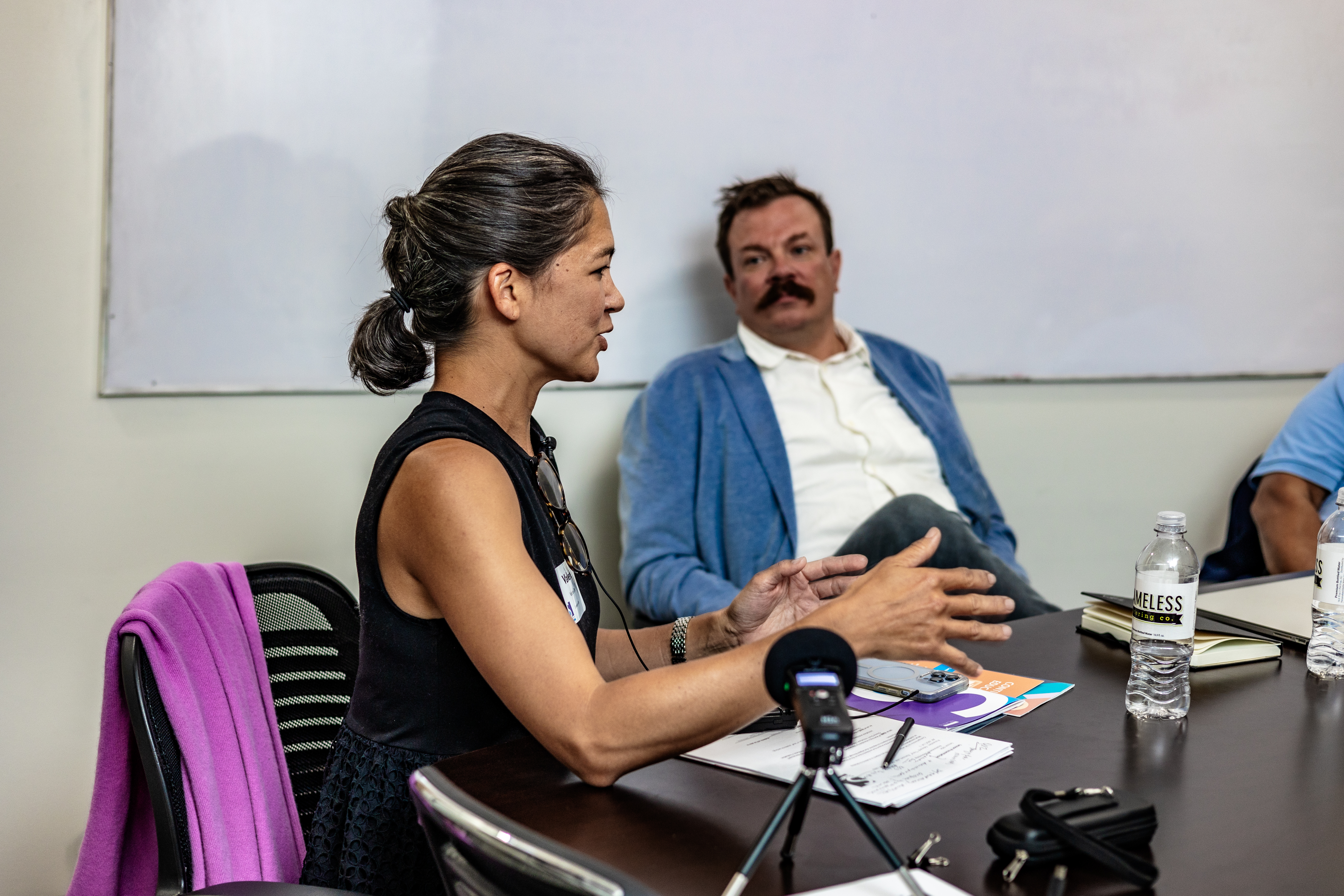 A woman speaks to other Scholars attendees in a conference room.