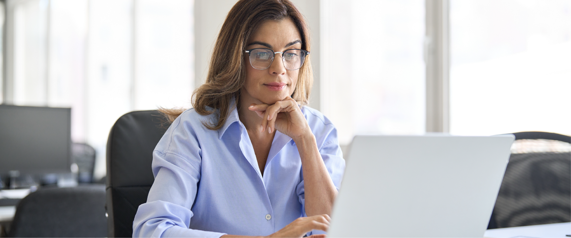 A woman researches how to get her architecture license on a laptop.