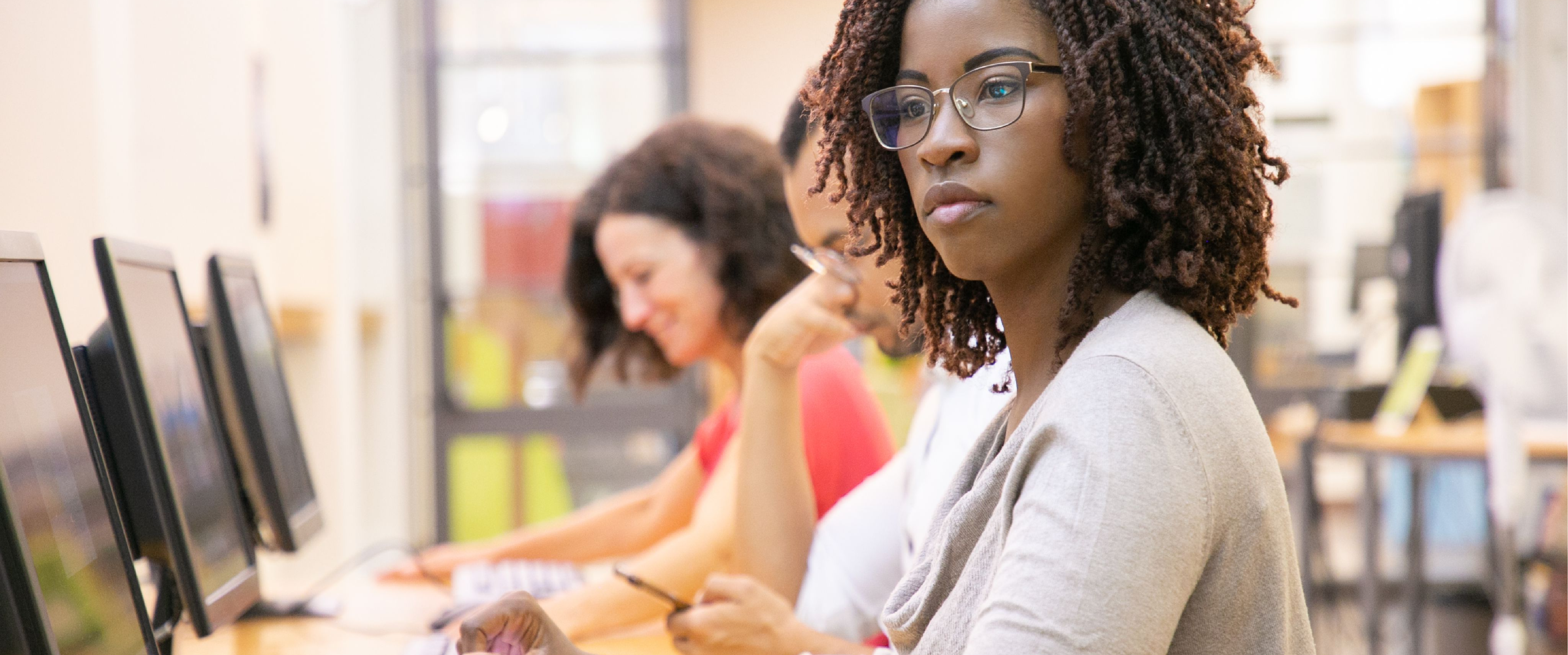 A woman of color looking at a computer. 