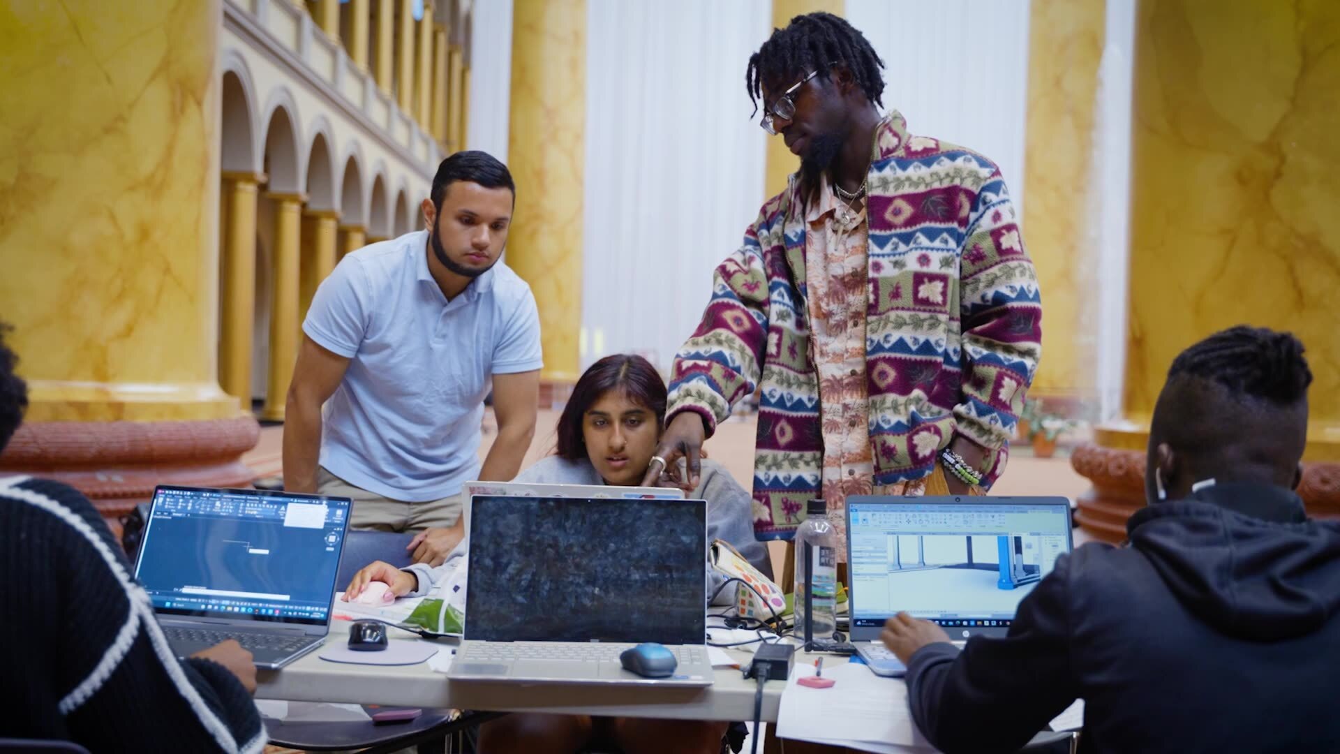 Architecture students talk and work together on a project.