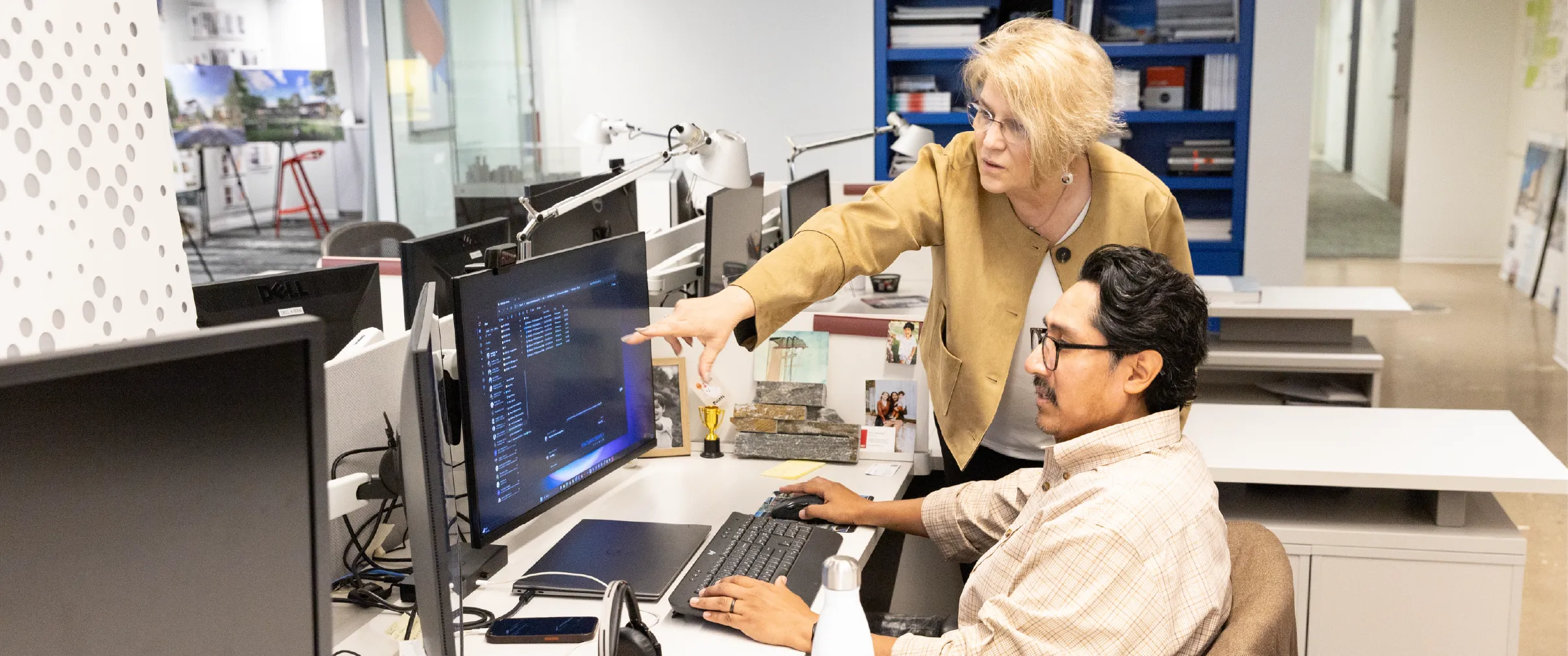 A licensing advisor points to a licensure candidate's computer screen in an office.