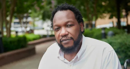 Headshot of Charles Jordan sitting in a park with trees in background
