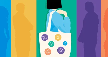 Person holds a tote bag with pronoun pins attached. 