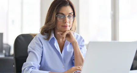 A woman researches how to get her architecture license on a laptop.