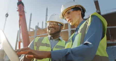 Two construction workers at a site. 