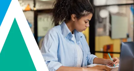A woman studying for the ARE at a desk. 