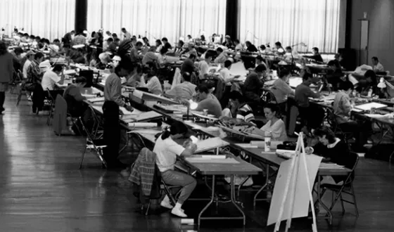 Licensure candidates take paper versions of the Architect Registration Examination in a large room during the 1990s.