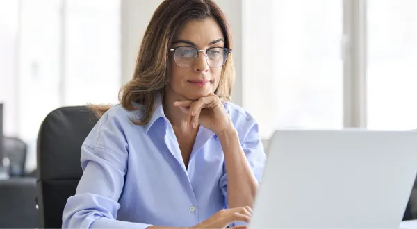 A woman researches how to get her architecture license on a laptop.