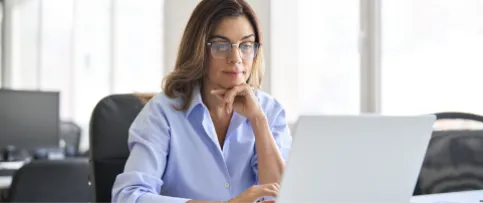 A woman researches how to get her architecture license on a laptop.