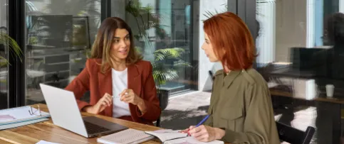 Two women engaged in a collaboration session. 