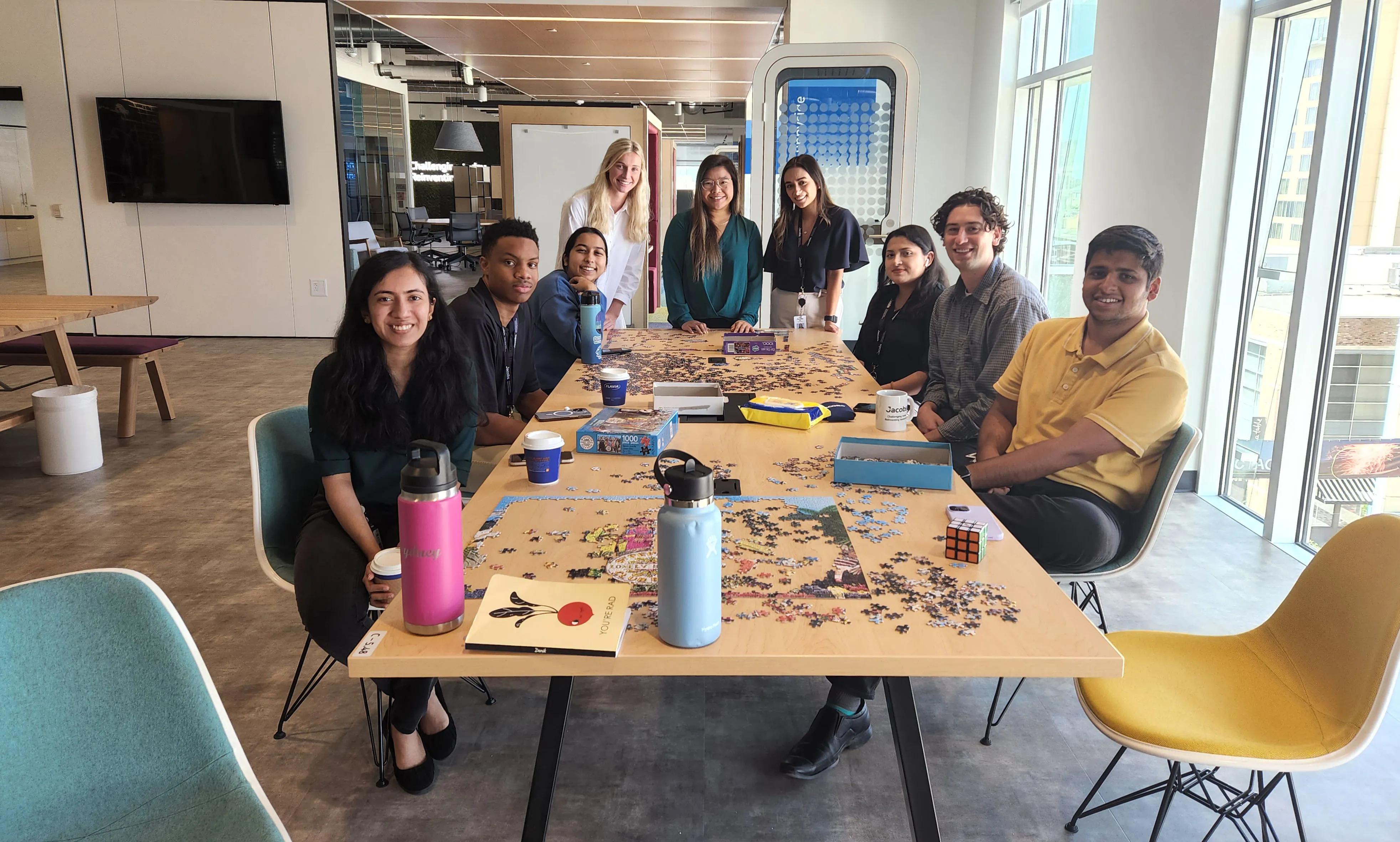 Sarah Mathews and Jacobs Houston's summer interns sit at a table.