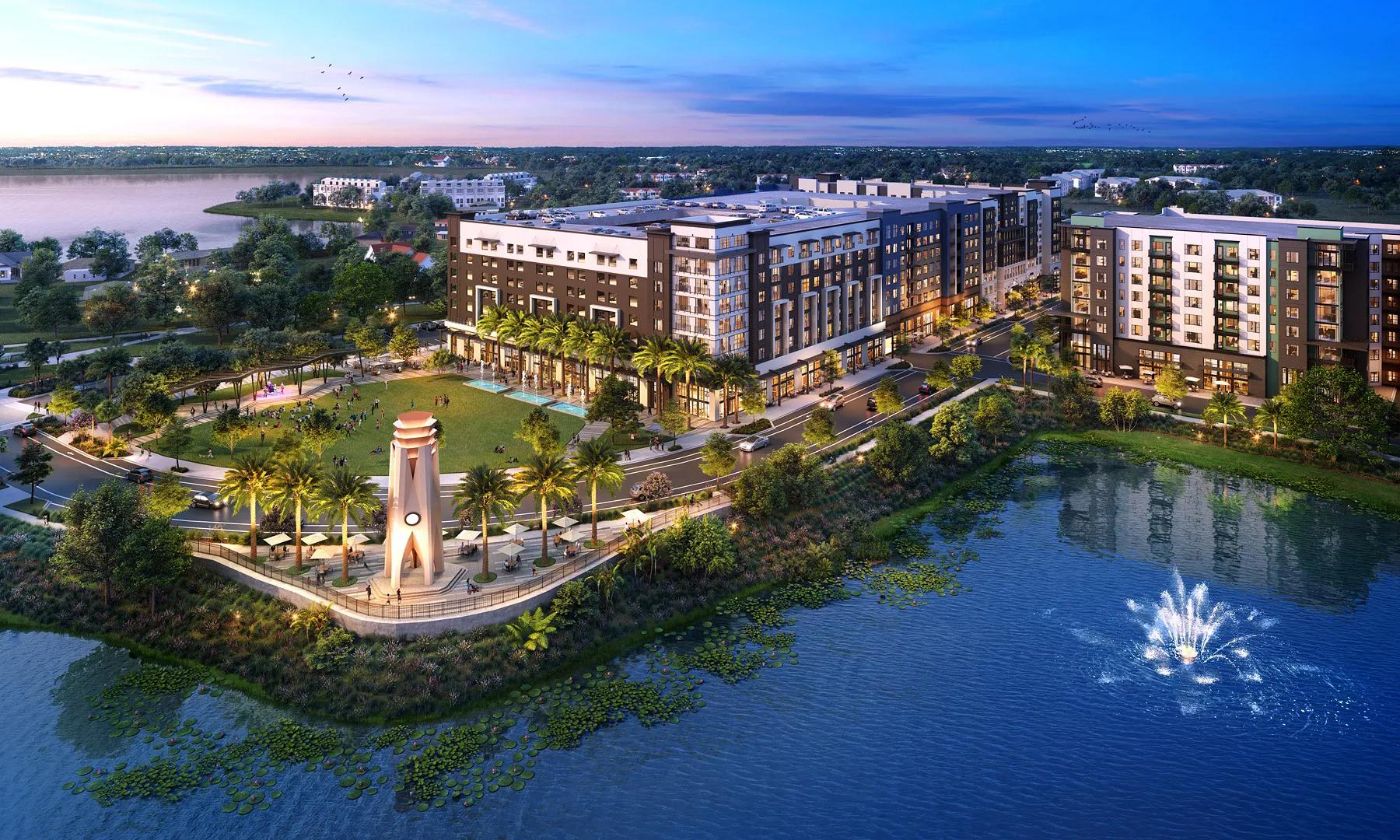 Several mixed-use buildings next to a park near a body of water.