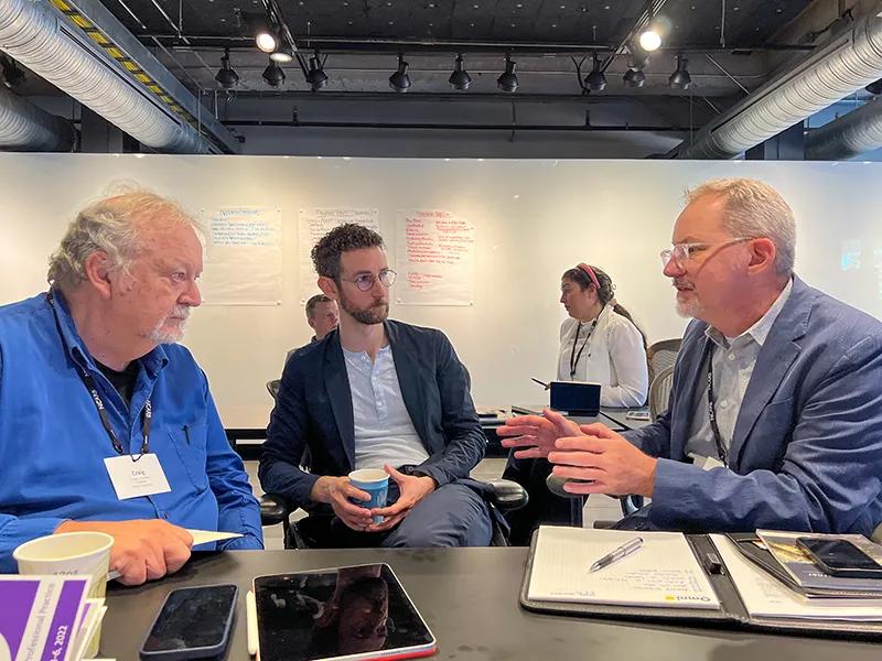 Professors discuss their courses in small groups.